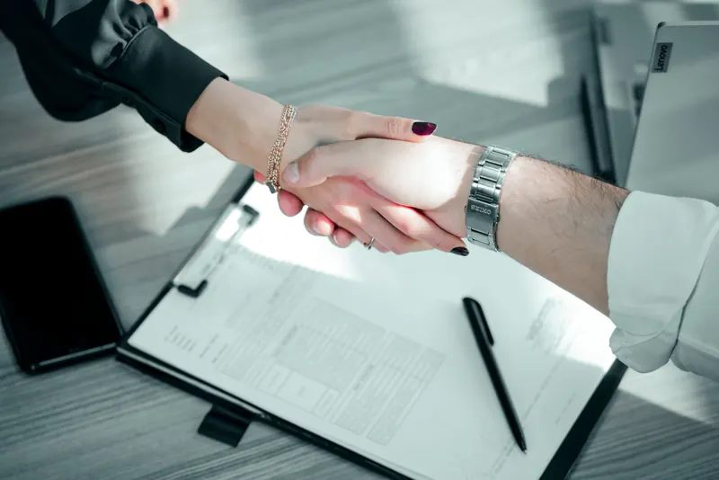 Poignée de main entre deux professionnels au-dessus d'un contrat de cession