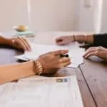 two people signing paperwork