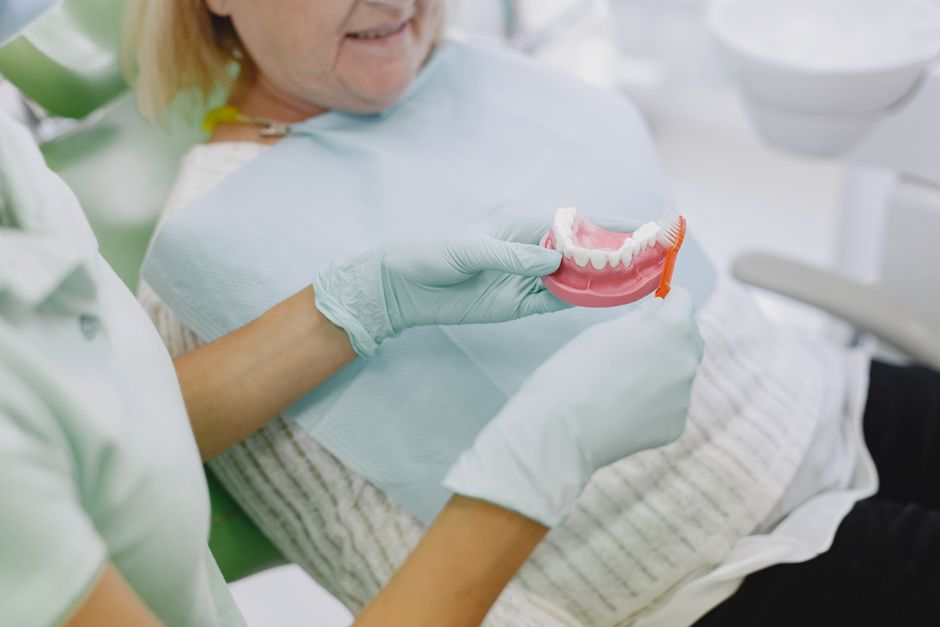 Une personne âgée surprise tenant un dentier